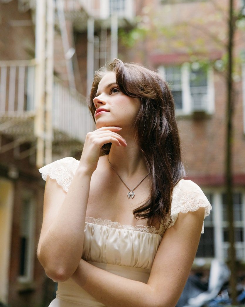 Edie posing in front of a brick building